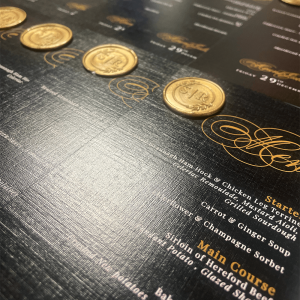 Black and gold wedding menu with wax seal